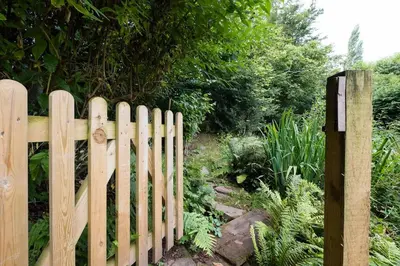 a wooden fence in front of a garden at Luxury Cottage near Hay-on-Wye in Llanigon