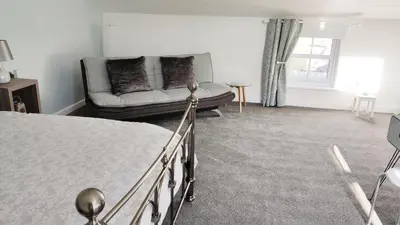 a bedroom with a bed and a couch at The Stables in Tregaron