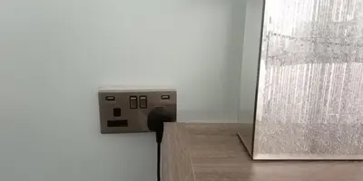 a electrical outlet on a wall next to a mirror at The Stables in Tregaron