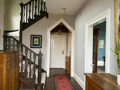 a hallway with a staircase and a white door at Kennet House in Ludlow