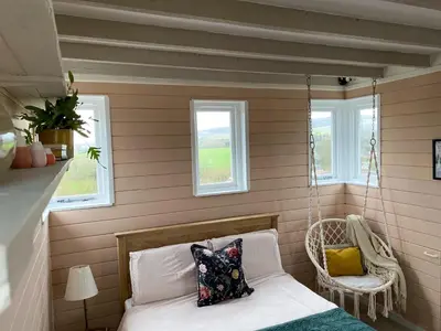 a room with a swinging bed and two windows at Kennet House in Ludlow