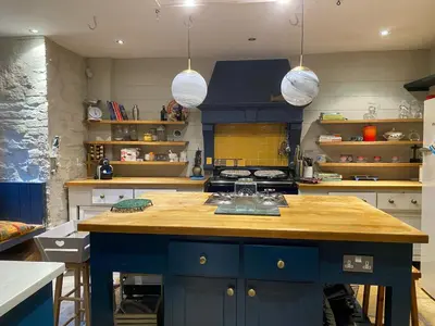 a kitchen with a blue island with wooden counter top at Kennet House in Ludlow