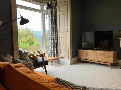 a living room with a tv and a large window at Kennet House in Ludlow