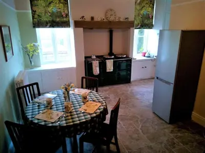 a kitchen with a dining table and a refrigerator at Tranquil getaway near Brecon Beacons in Llandovery