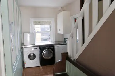 a laundry room with a washing machine and a window at Country Mansion - Private Annexe in Llanwrda