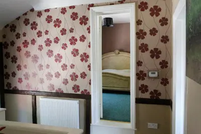 a mirror in a room with flowers on the wall at Country Mansion - Private Annexe in Llanwrda