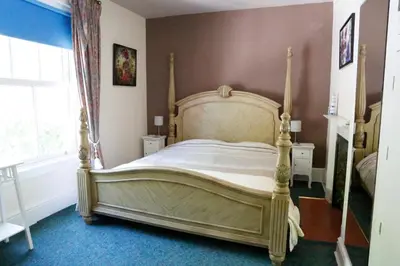 a bedroom with a large bed in a room at Country Mansion - Private Annexe in Llanwrda