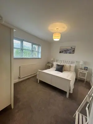a bedroom with a white bed and a window at BROOK HOUSE 4a in Llangollen