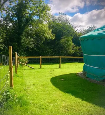 a yard with a fence and a gazebo at 'Villager' the Yurt at Pentref Luxury Camping in Penuwch