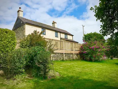 a large house with a green yard in front of it at Tan Y Llidiart in Llangedwyn