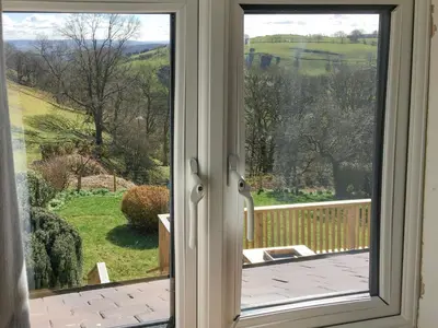 a door to a balcony with a view of a yard at Tan Y Llidiart in Llangedwyn