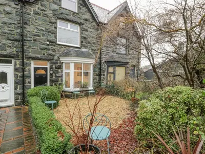 a stone house with a garden in front of it at Bronwen House in Llanbedr
