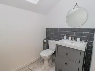 a bathroom with a toilet and a sink and a mirror at Bronwen House in Llanbedr