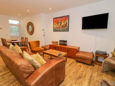 a living room with a couch and a flat screen tv at Bronwen House in Llanbedr
