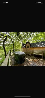 a large tub sitting on top of a wooden deck at Chestnut Tree House with Hot tub & Sauna in Barmouth