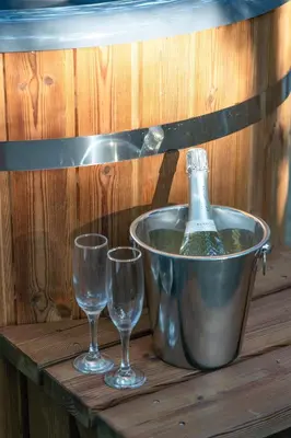 two wine glasses and a bottle in a bucket at Pine Tree House with Hot tub & Sauna in Barmouth