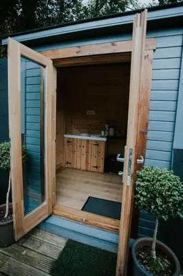 an open door of a shed with two plants at River Side Cabin with Hot tub Snowdonia in Barmouth