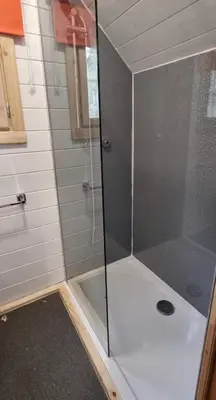 a shower with a glass door in a bathroom at Woodland Cabin with Private Hot Tub in Barmouth