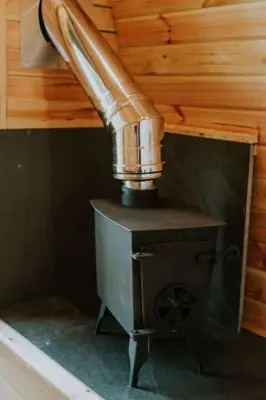 a pipe sticking out of a stove in a room at Oak SPECIAL WINTER OFFERS - Hot tub in Barmouth
