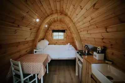 a bedroom in a log cabin with a bed and a sink at Oak SPECIAL WINTER OFFERS - Hot tub in Barmouth
