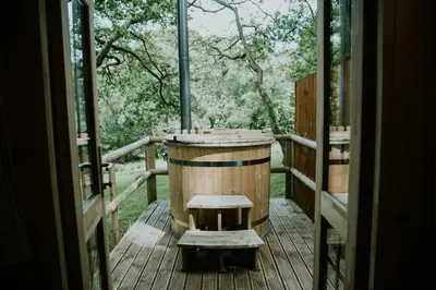 a wooden barrel sitting on a wooden deck at Oak SPECIAL WINTER OFFERS - Hot tub in Barmouth
