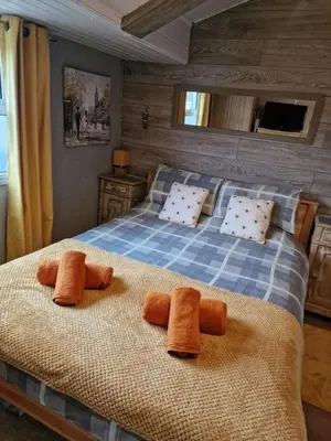 a bedroom with a bed with orange towels on it at Chalet 88 in Aberystwyth