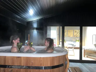 two women are sitting in a hot tub at Quirky, Luxury Hideaway in Llanbrynmair