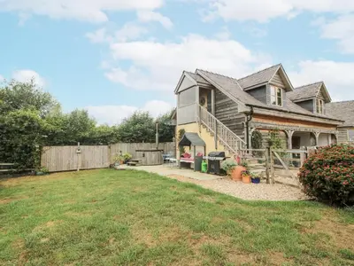 a house with a fence and a yard at Stable Cottage in Bishops Castle