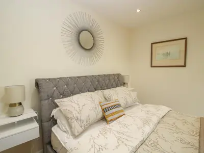 a bedroom with a bed with a mirror on the wall at Stable Cottage in Bishops Castle
