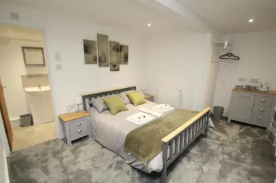 a bedroom with a large bed with green pillows at The Slaters Arms Corris in Machynlleth