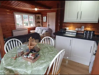 a kitchen with a table and chairs with a table and a room at Snowdonia Escapes # TRANQUIL CABIN with Views, Wi-Fi, Dog Friendly & Parking in Trawsfynydd