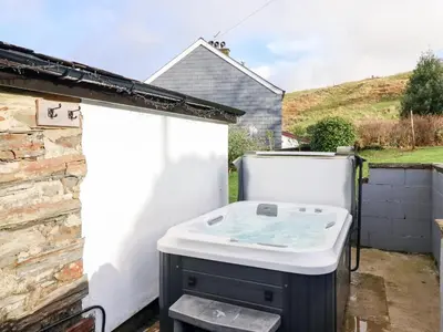a bath tub sitting in the backyard of a house at Ael Y Bryn in Blaenau-Ffestiniog