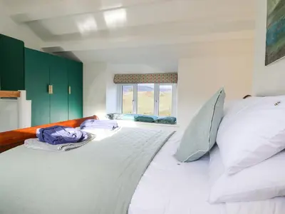 a large white bed in a room with a window at Ael Y Bryn in Blaenau-Ffestiniog