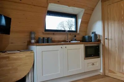 a kitchen with a sink and a window at Eastridge Glamping Pods in Shrewsbury