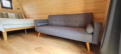 a bedroom with a couch and a bed in a room at Eastridge Glamping Pods in Shrewsbury