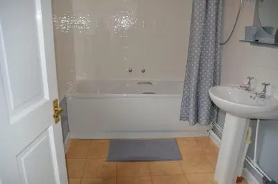 a bathroom with a bath tub and a sink at The Coach House at Copper Hall in Leominster