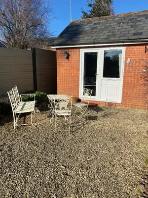 two chairs and a table in front of a house at The Coach House at Copper Hall in Leominster