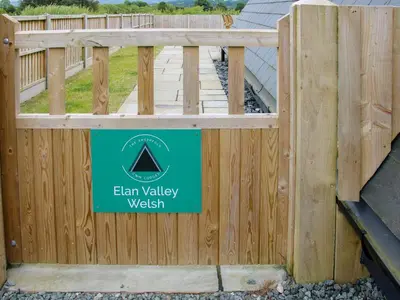 a wooden fence with a sign on it at Elan Valley Welsh - The Sheepfold in Llandrindod Wells