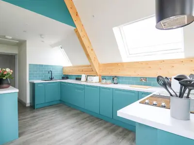 a kitchen with blue cabinets and a skylight at Kerry Hill - The Sheepfold in Llandrindod Wells