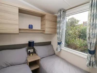 two beds in a small room with a window at Gwent 74 in Borth