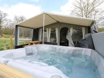 a hot tub with a tent in the background at Otter in Nantmel