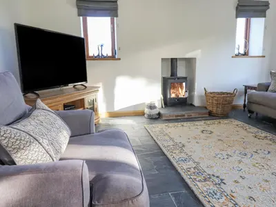 a living room with a tv and a fireplace at Cwmwr in Pen-y-bont-fawr