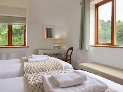 two beds in a white room with towels on them at Cwmwr in Pen-y-bont-fawr