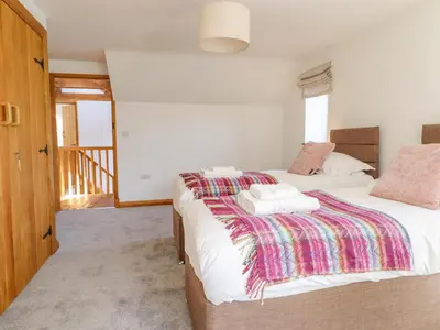 a bedroom with two beds with towels on them at Cwmwr in Pen-y-bont-fawr