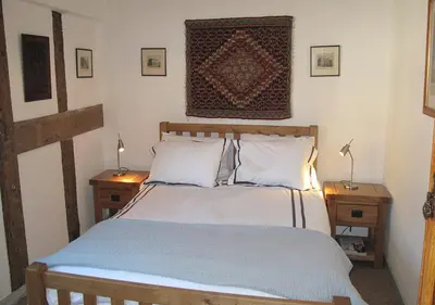 a bedroom with a large bed with two night tables at Corve Cottage Historic cottage in beautiful ludlow in Ludlow