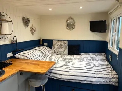 a bedroom with a bed with blue and white stripes at Ramblers retreat in Shrewsbury