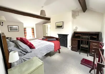 a bedroom with a bed and a desk and a piano at Glan y Morfa Welsh farmhouse overlooking Dyfi Estuary Rated 4 star Visit Wales in Pennal