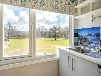 a kitchen with a sink and a large window at Tynrhos Lake View in Cilcennin
