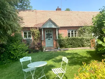 two chairs and a table in front of a house at Divine, detached countryside cottage near Ludlow. in Ludlow