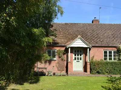 a red brick house with a white door at Divine, detached countryside cottage near Ludlow. in Ludlow